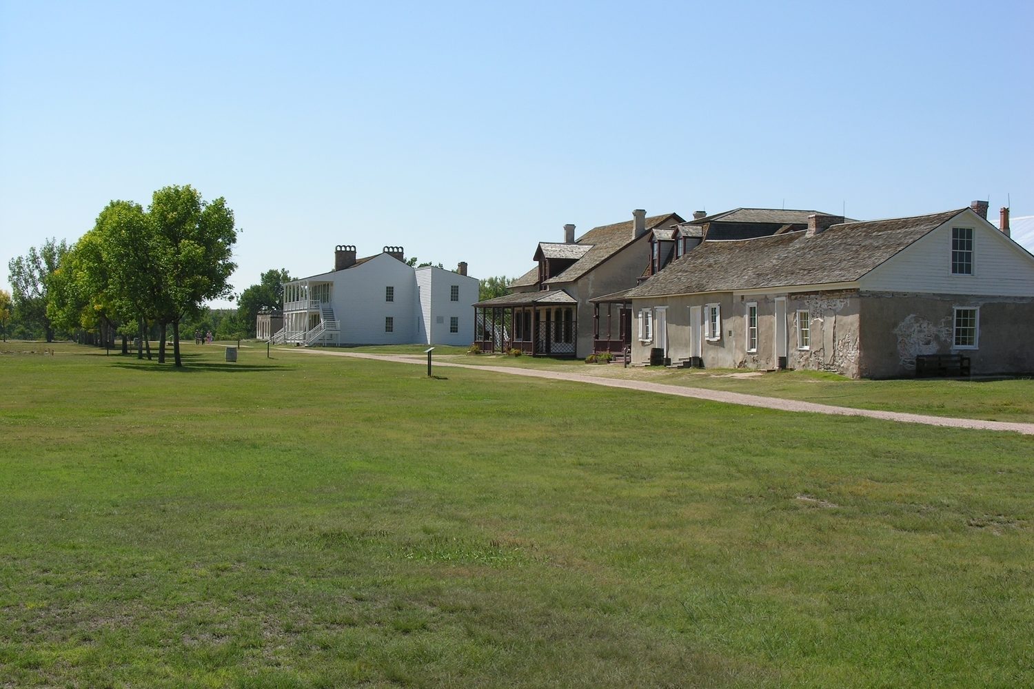 The restored buildings of Fort Laramie across a green parade ground.